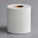 A Scott Essential center-pull paper towel roll on a gray surface.