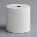 A white roll of Scott Essential Hard Roll Paper Towels on a gray surface.
