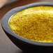 A bowl of yellow powder, Regal Southwestern Blend, on a table.