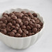 A white bowl filled with Callebaut dark chocolate chips.