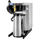 A Newco airpot coffee maker with a stainless steel filter and black lid.