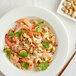 A bowl of food with shrimp and cashews.