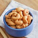 A blue bowl filled with Regal Large Roasted Unsalted Cashews.
