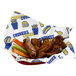 A white EcoChoice basket liner with a custom design in a basket of chicken wings, carrots, and celery.