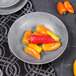 A Denali cement melamine bowl filled with chili peppers on a table.