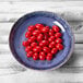 An Elite Global Solutions Monet indigo melamine bowl filled with cherry tomatoes on a table.