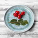 An Elite Global Solutions Monet sea moss melamine plate with cherry tomatoes and leaves.