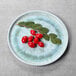 An Elite Global Solutions Monet sea moss melamine plate with red berries and leaves on it.