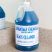 A case of four blue and white jugs of Advantage Chemicals ready-to-use glass cleaner on a counter.