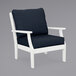 A white POLYWOOD outdoor arm chair with a blue cushion.