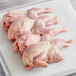 Fresh Manchester Farms quail butterfly cuts on a white surface.
