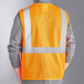 A person wearing an orange Ergodyne reflective safety vest.