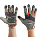 A pair of large Ergodyne ProFlex heavy-duty work gloves with orange and grey accents on a pair of hands.