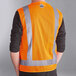 An orange Ergodyne surveyor vest with reflective stripes on a person.