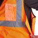 An orange Ergodyne high visibility vest with black accents and reflective tape.