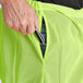 A person holding a pair of lime green and black pants.