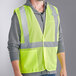 A man wearing a lime Ergodyne high visibility mesh vest.