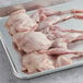 A tray of raw Manchester Farms semi boneless quail with feet.