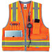 An orange Ergodyne heavy-duty surveyor vest with a phone and a pen in the pockets.