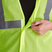 A person pulling a lime yellow Ergodyne GloWear safety vest.