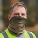 A man wearing an Ergodyne khaki multi-band face covering over his face.