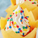 A cupcake with white frosting and Bold Confetti Sequin Sprinkles on top.