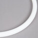 A white circular gasket for a Cambro Camtainer on a gray surface.