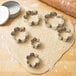 Ateco stainless steel cookie cutter set with flower shapes on cookie dough.