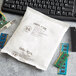 A white bag of Multisorb NatraSorb silica packets with text next to computer chips and a keyboard.