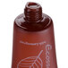 A close-up of an Ecossential Naturals 0.5 oz. bottle of brown body wash with a lid.