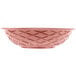 A pink round weave basket with a diamond pattern.