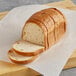 A sliced loaf of Schar gluten-free white bread on a cutting board.