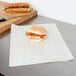 A sandwich wrapped in Choice newsprint paper on a plate.