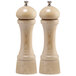 Two round wooden pepper mills with silver tops.