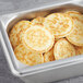 A metal container filled with White Toque mini blini pancakes.