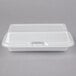 A white styrofoam container with a hinged lid.