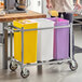 A mobile triple ingredient bin with yellow, white, and purple containers on a metal frame with wheels.
