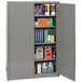 An Eagle Manufacturing gray metal safety cabinet with shelves full of books and other items.