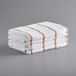 A stack of Monarch Brands white towels with brown stripes.