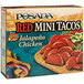 A box of mini red tacos filled with chicken.
