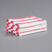 A stack of pink and white striped Monarch Brands Cali Cabana pool towels.