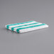 A white towel with teal and green stripes.