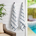 Two Monarch Brands navy striped towels hanging on a wall.