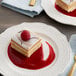 A piece of cake with Les Vergers Boiron red raspberry puree on a white plate.