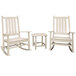 A group of three white POLYWOOD Vineyard rocking chairs with a white table.