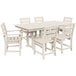 A POLYWOOD white farmhouse table and chairs on an outdoor patio.
