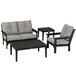 A group of POLYWOOD patio furniture with black frames and grey cushions, including a table.