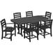 A black POLYWOOD La Casa Cafe dining table with a wooden top and six matching chairs on an outdoor patio.