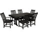 A black POLYWOOD dining table with a Nautical Trestle base and six armchairs.