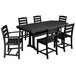 A black POLYWOOD dining table with a Nautical trestle base and six matching chairs on an outdoor patio.